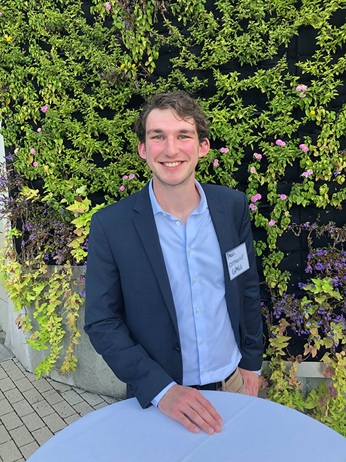 Paul Cipparone standing in front of a table outdoors, greenery behind him. 